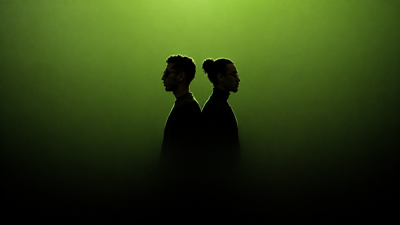Two silhouettes back to back in the Wenix signature green haze